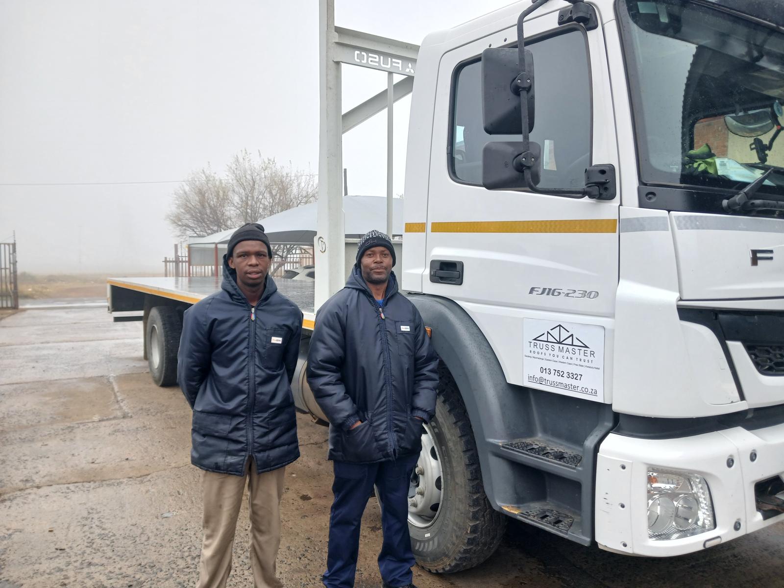 A Truss Master delivery truck with its drivers
