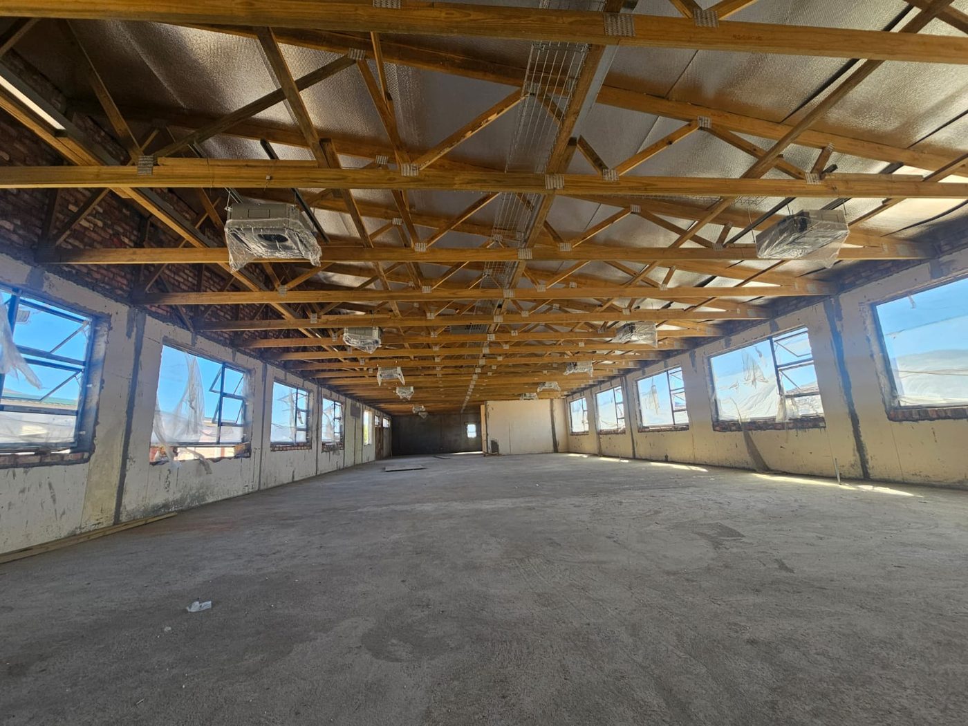 Long-span timber roof trusses over a large warehouse floor